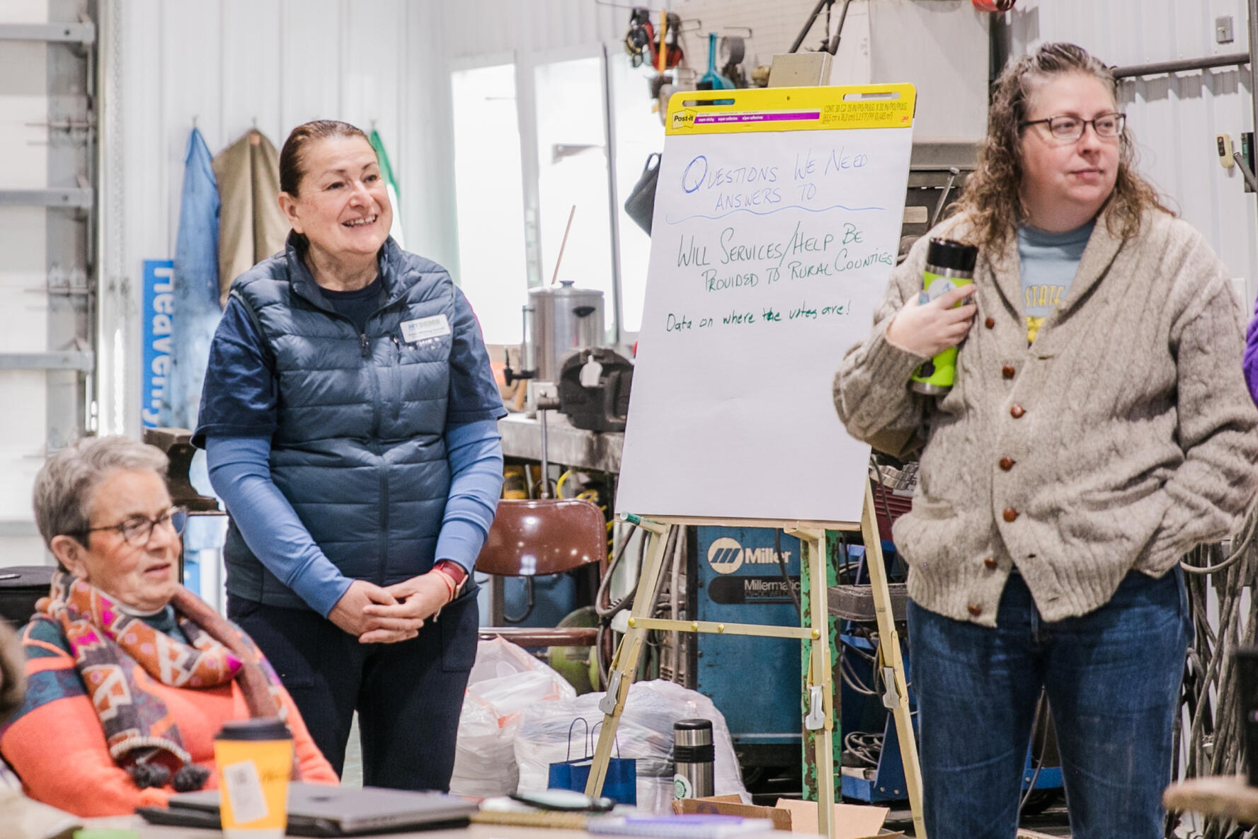Six youth stand at a wall drawing ideas on a long sheet of paper.