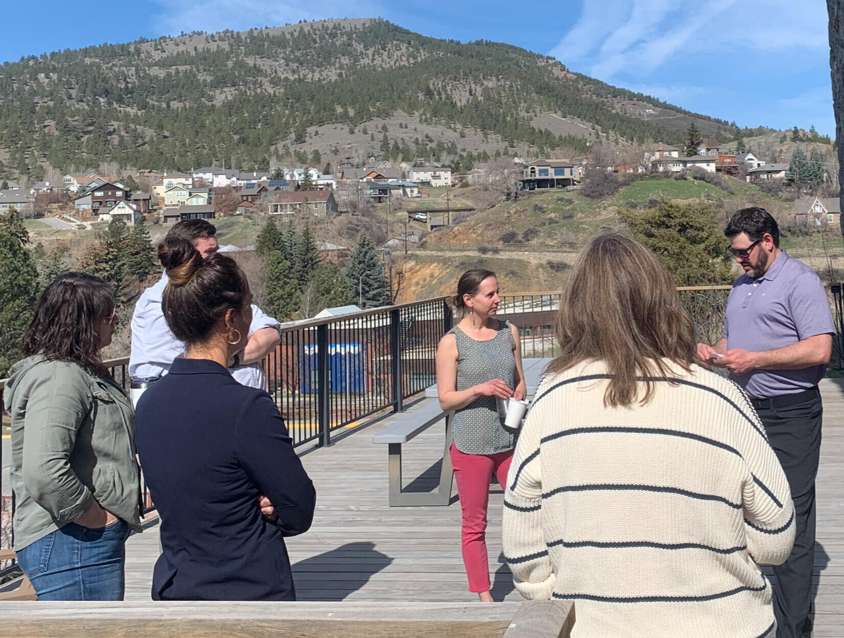 Six youth stand at a wall drawing ideas on a long sheet of paper.